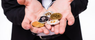 человек держит монеты криптовалюты на руках