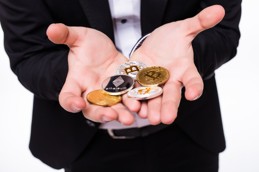 человек держит монеты криптовалюты на руках